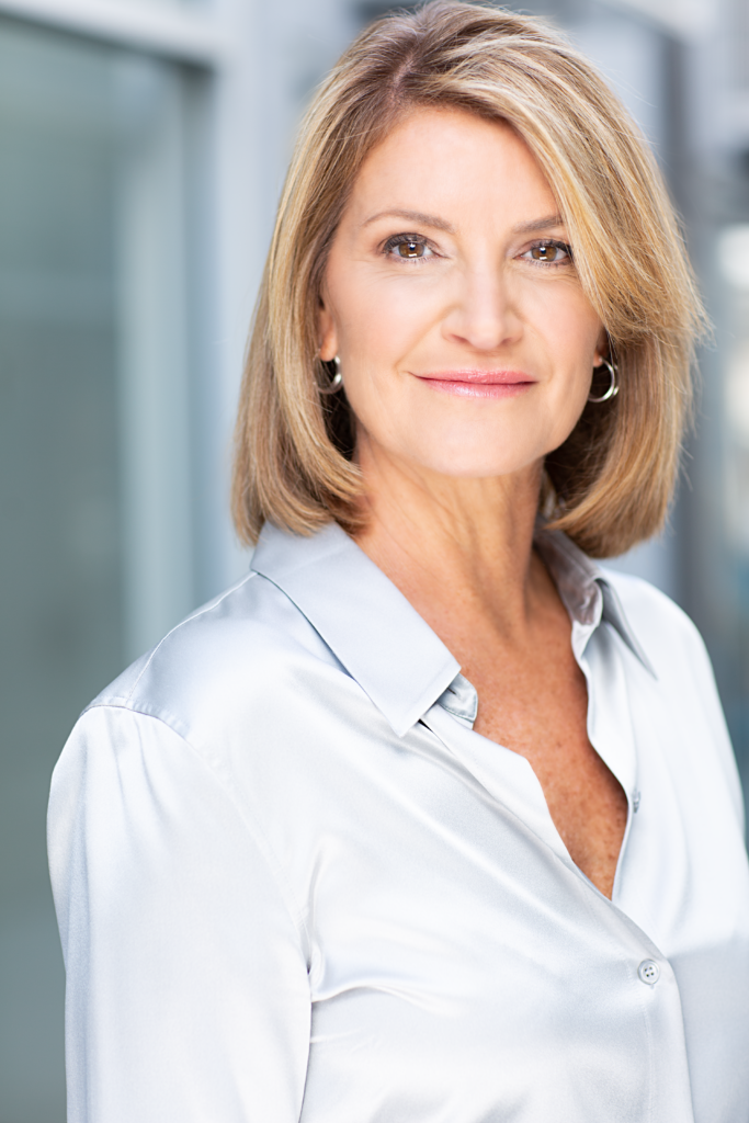 photo of Julie Case, a white woman with shoulder length blonde hair, wearing a light blue button down shirt