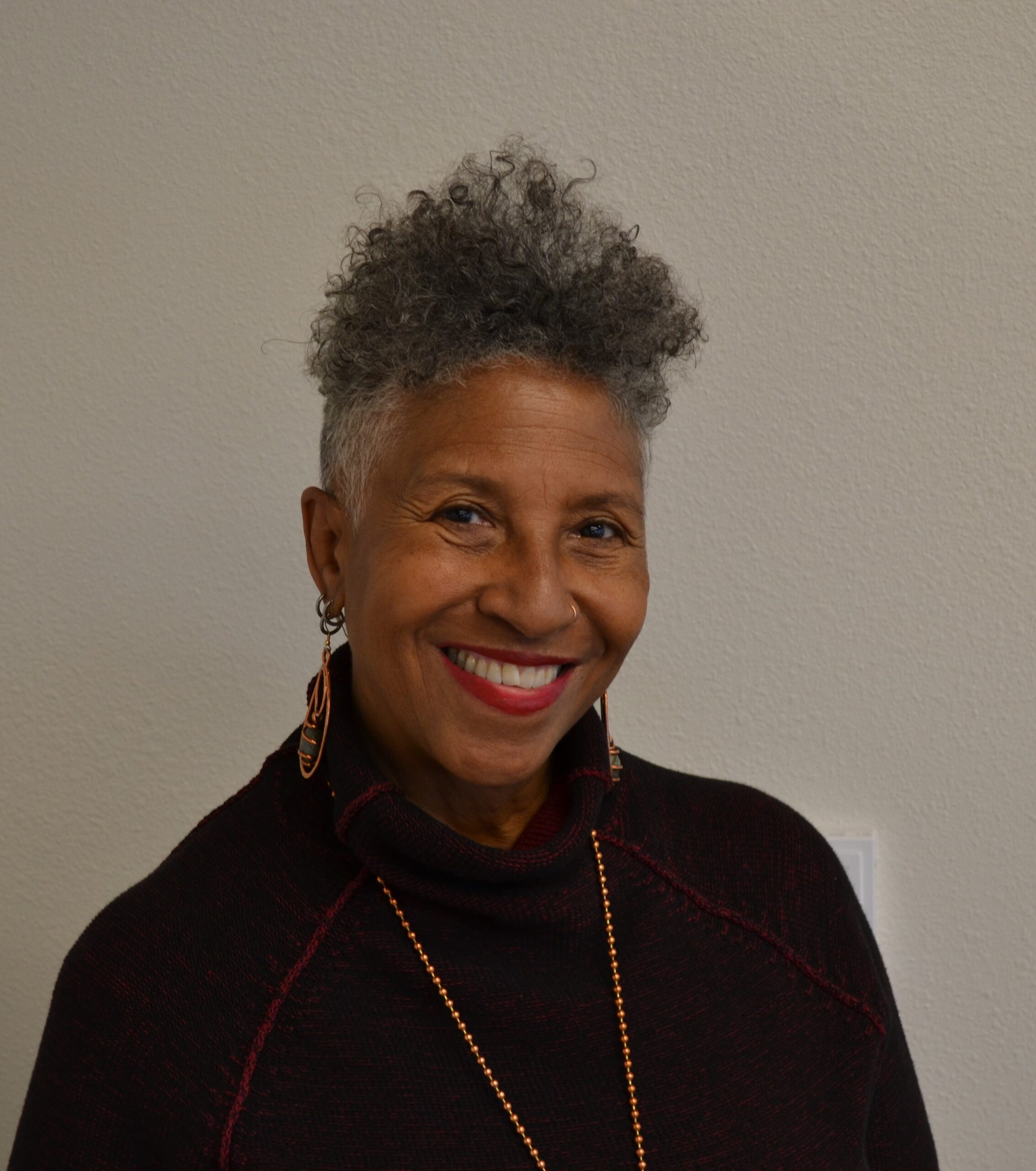 Image of Edali Pollard, a middle-aged smiling black woman wearing a dark red turtle neck.