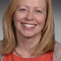 photo of Bronagh Lavery, a smiling middle aged white woman with shoulder length strawberry blonde hair, wearing an orange blouse